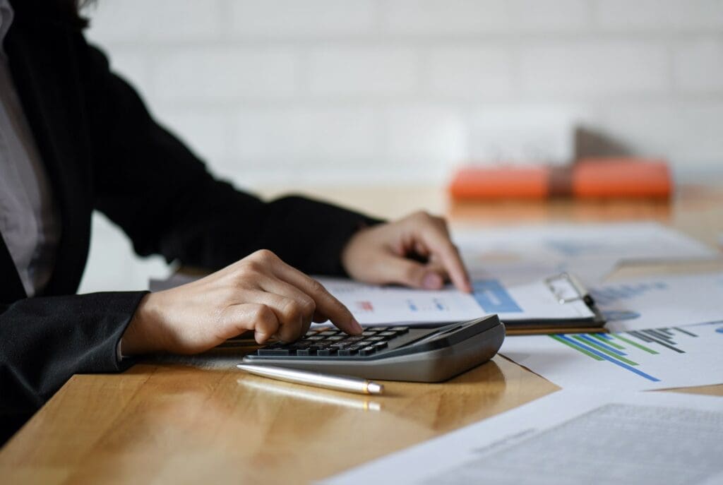 Start up business concepts, Accounting staff is summarizing the company budget. She uses a calculator and analyzes the data graph, Accounting concept.