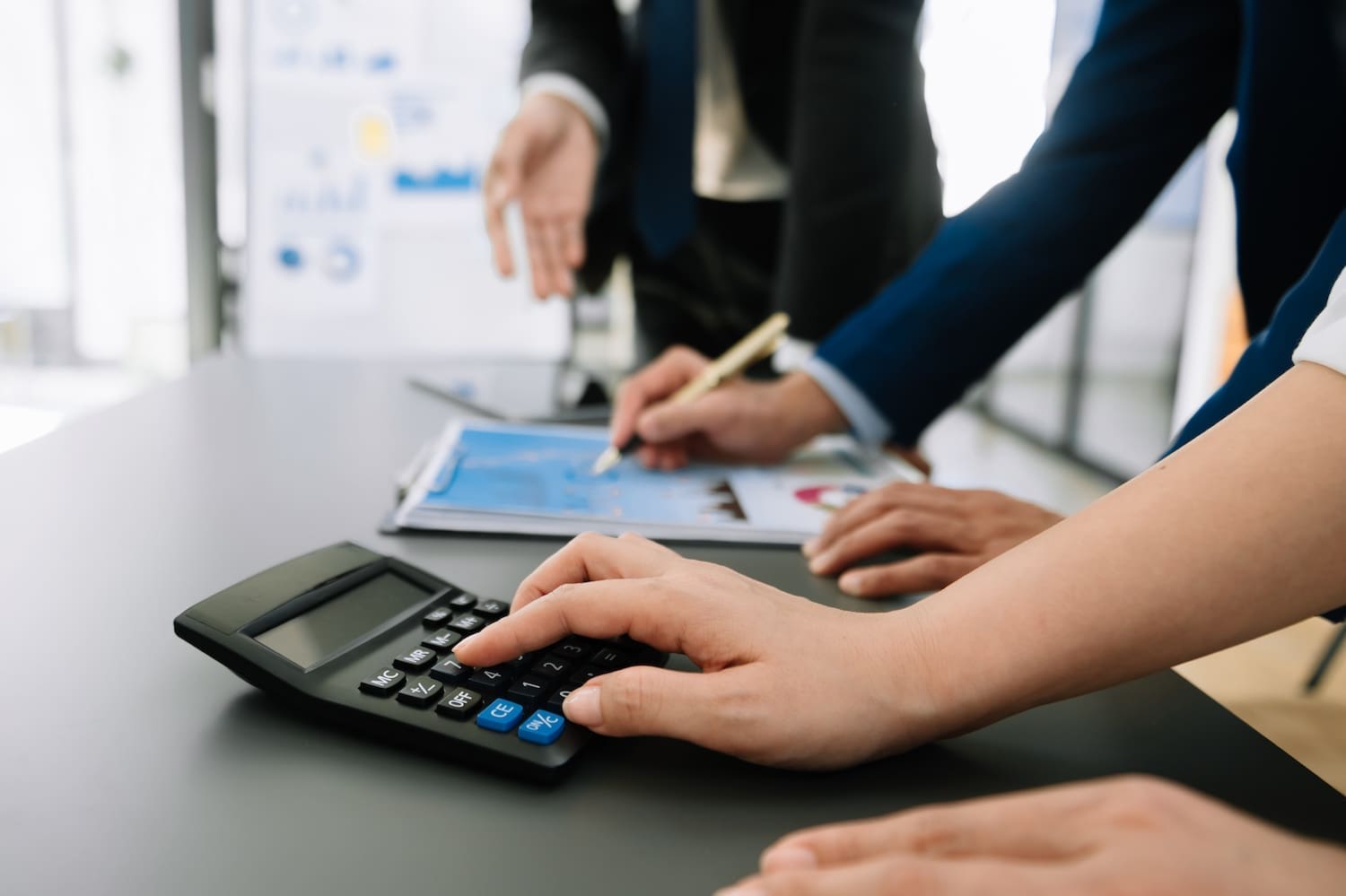 Businessman hands working with finances about cost and calculator and laptop with tablet, smartphone at office